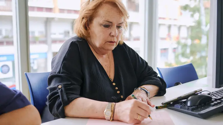 Una persona mayor participando en uno de los talleres de escritura creativa. Fundación la Caixa