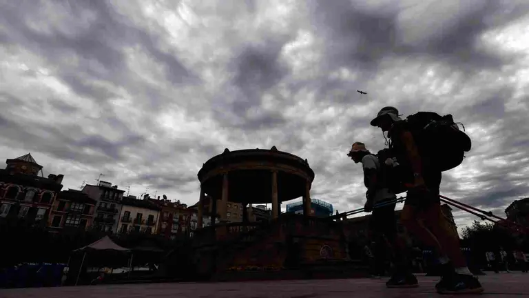 Dos turistas pasean por la Plaza del Castillo de Pamplona con un cielo tormentoso en una jornada donde la Agencia Estatal de Meteorología anuncia para este jueves en Navarra chubascos y tormentas localmente fuertes y un descenso notable de las temperaturas máximas. Se esperan cielos nubosos, con nubes altas al principio en la mitad sur, que aumentarán a cubiertos a partir de mediodía, con brumas y probables nieblas dispersas en zonas altas de la mitad norte al principio y final del día. Asimismo anuncia chubascos tormentosos y tormentas que con menos probabilidad serán localmente fuertes y acompañadas de granizo y que serán algo más dispersas en la mitad oriental. EFE/ Jesus Diges