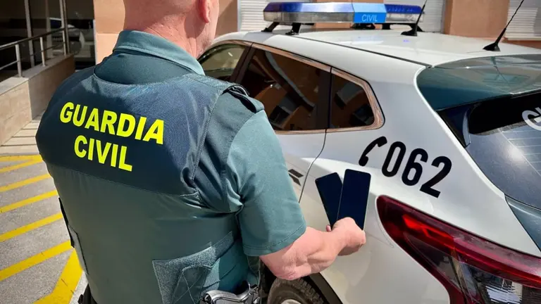 Un agente de la Guardia Civil con móviles recuperados tras ser sustraidos en fiestas de Sarriguren. GUARDIA CIVIL