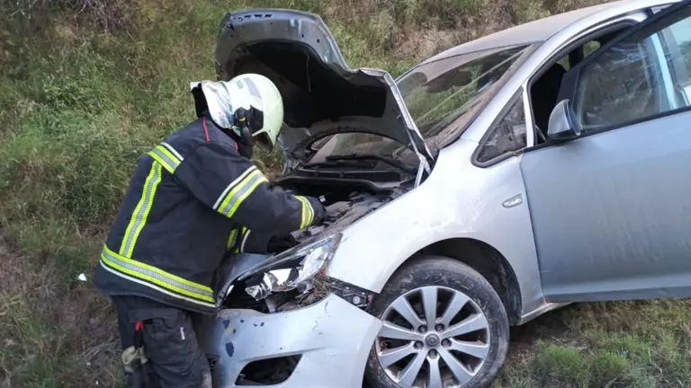 Imagen de un bombero trabajando en el vehículo accidentado en Funes. BOMBEROS DE NAVARRA