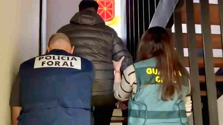 Uno de los detenidos es custodiado y conducido por un agente de la Policía Foral y una agente de la Guardia Civil. GUARDIA CIVIL DE NAVARRA