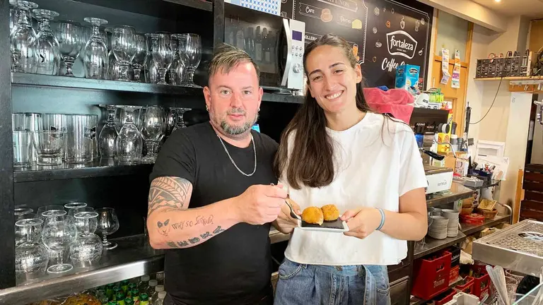 Santiago Salguero y una empleada del gastrobar La Plaza sostienen la croqueta de toro. Navarra.com