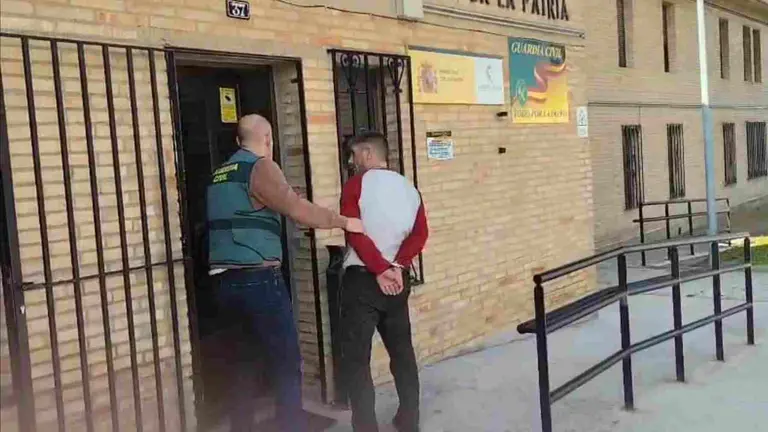 El detenido es conducido por un agente al cuartelillo. GUARDIA CIVIL