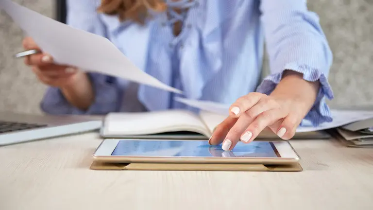 Una persona trabajando con una tablet en una oficina. PRESSFOTO - FREEPIK