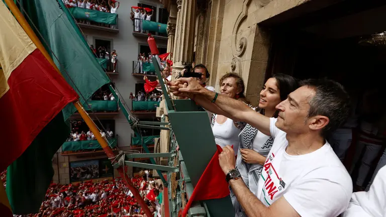 Los tres representantes de Yala Nafarroa por Palestina Dyna Kharrat (c), Lidón Soriano (i) y Eduardo Ibero realizan el Chupinazo con el que comienzan los Sanfermines desde el balcón del ayuntamiento de Pamplona, este domingo. EFE/ Jesús Diges