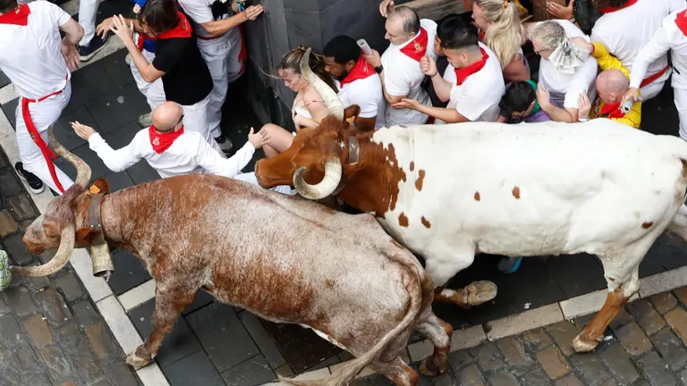 Los mozos se arrinconan en una esquina al paso de los toros de la ganadería gaditana de Fuente Ymbro durante el primer encierro de los Sanfermines 2025, este lunes en Pamplona. EFE Jesús Diges