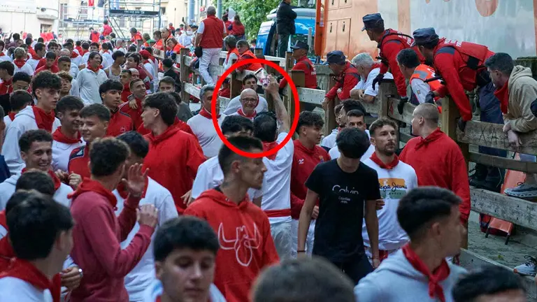 De espaldas y dentro del círculo rojo, un hombre graba con el móvil el encierro de San Fermín. IRANZU LARRASOAÑA