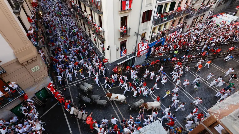 Sexto encierro de San Fermín 2025 el día 12 de julio con toros de José Escolar en la curva de Mercaderes. EFE - VILLAR LÓPEZ (1)