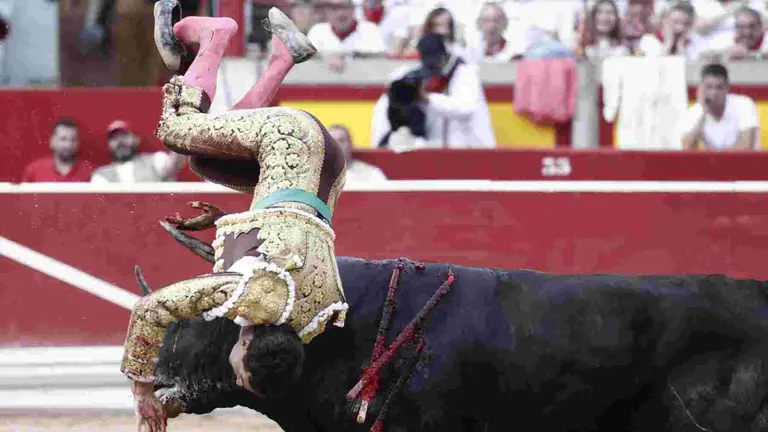 El torero Fernando Adrián sufre un revolcón durante la lidia a su segundo toro de la tarde en la novena de abono de la Feria de Toro de los Sanfermines 2025 con toros de la ganadería gaditana La Palmosilla y en la que comparte cartel con los diestros Jiménez Fortes y Ginés Marín. EFE/Jesús Diges