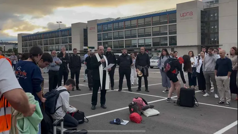 Bendición del arzobispo, Monseñor Florencio Roselló, en el aparcamiento de la UPNA antes de la salida de los 600 jóvenes navarros rumbo a Roma.