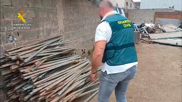 Imagen de archivo de un agente de la Guardia Civil junto a los poste de espaldera de viñedos recuperados. GUARDIA CIVIL