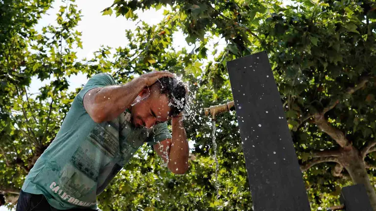 Una persona se refresca en una fuente de la Plaza del Castillo en un d&iacute;a de calor. EFE/ Jes&uacute;s Diges