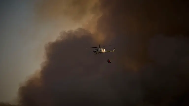 Efectivos de Bomberos, Polic&iacute;a Foral, Guardia Civil, aviones y helic&oacute;pteros trabajan para sofocar el incendio forestal declarado en Carcastillo. PABLO LASAOSA