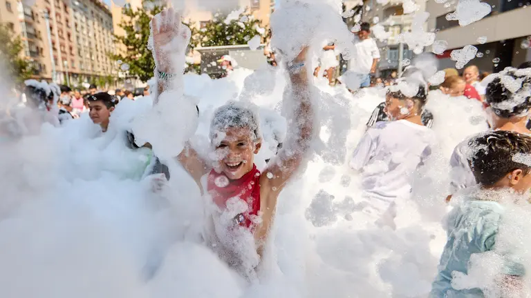 Niños y niñas juegan en la fiesta de la espuma tras el chupinazo de inicio de las Fiestas de Burlada 2025. IÑIGO ALZUGARAY