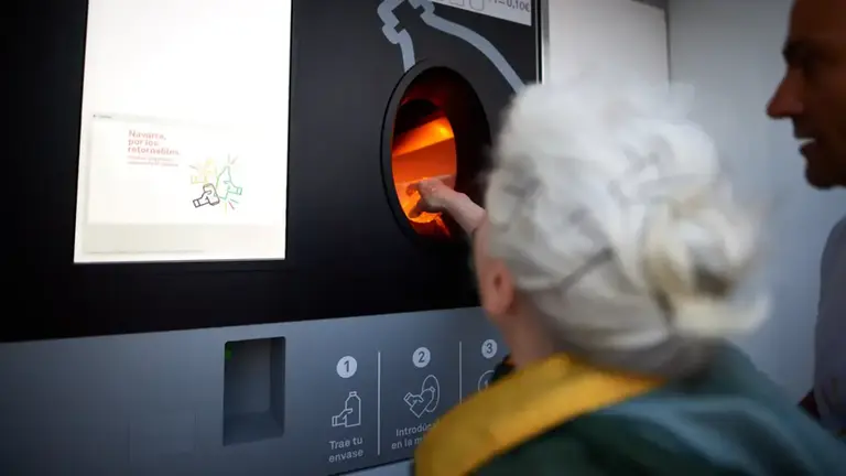 Una mujer introduce una botella de plástico en una máquina, y esta le devuelve 10 céntimos. DANIEL FERNÁNDEZ / ARCHIVO