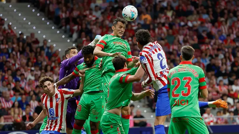 El delantero del Osasuna Ante Budimir (c) remata un balón durante el encuentro correspondiente a la novena jornada de LaLiga EA Sports que disputan hoy sábado Atlético de Madrid y CA Osasuna en el estadio Metropolitano de Madrid. EFE/ Mariscal