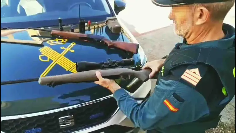 Un agente de la Guardia Civil con las armas que utilizaban los furtivos. GUARDIA CIVIL DE NAVARRA