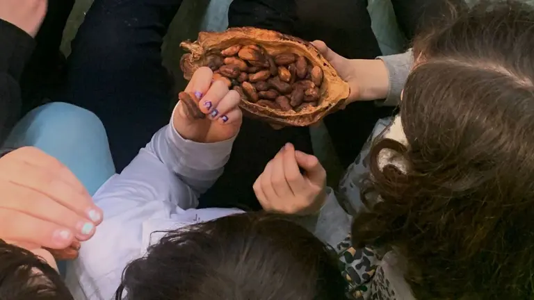 Imagen de unos niños con un fruto de cacao. CEDIDA