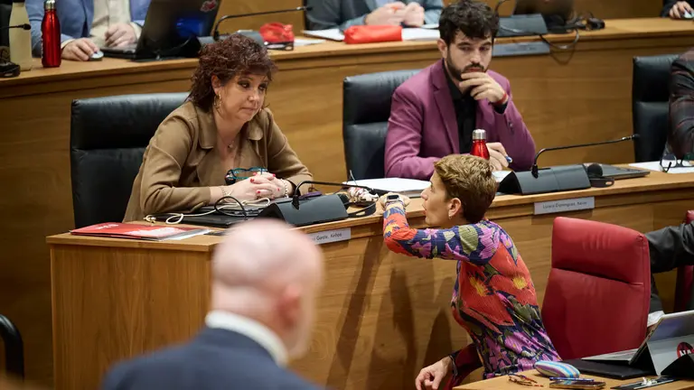 María Chivite conversa con la portavoz del PSN en el Parlamento, Ainhoa Unzu, durante la intervención de Javier Esparza (UPN). PABLO LASAOSA