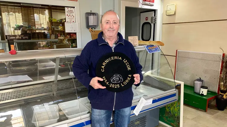 Julio Izkue sostiene la txapela que le regalaron tras jubilarse en su carnicer&iacute;a de Lorca. Navarra.com
