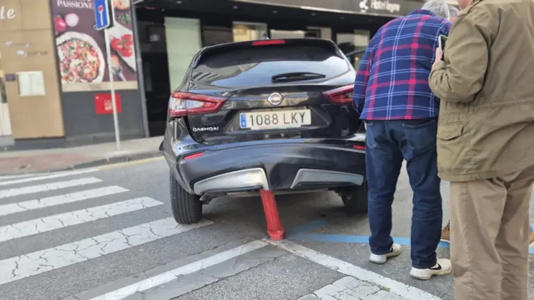 Un coche enganchado en un pivote en la calle de Leyre en Pamplona. CEDIDA