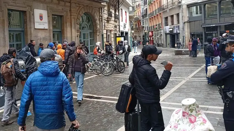Inmigrantes sin techo ante las oficinas de bienestar social del Ayuntamiento de Pamplona.