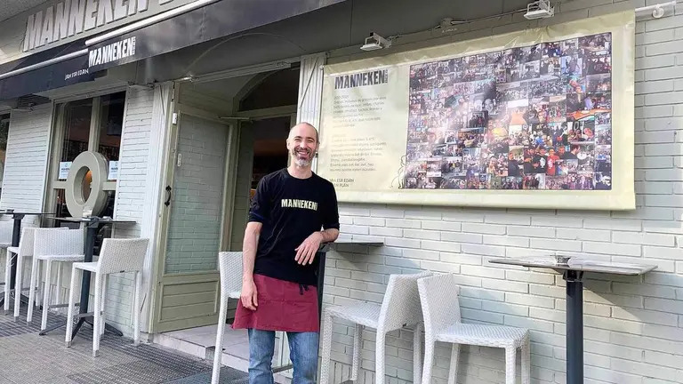 Eneko M&eacute;ndez junto al cartel que ha colocado en la fachada de su cervecer&iacute;a en Pamplona. Navarra.com