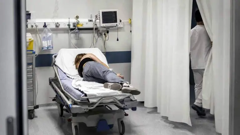 Un mujer es atendida en el box de urgencias de un hospital.