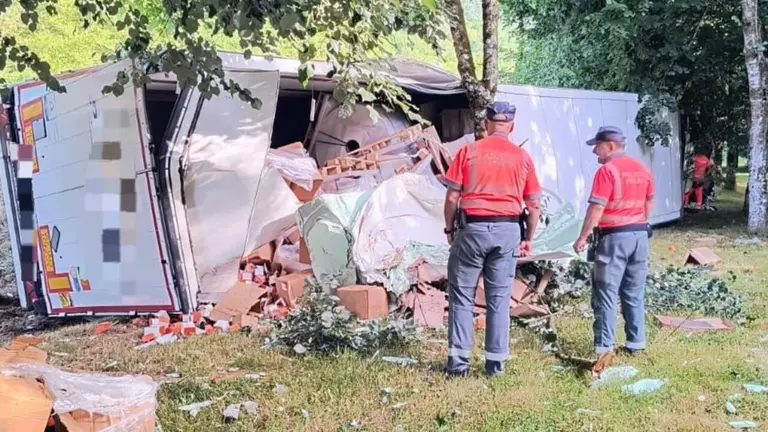 Dos polic&iacute;as forales inspeccionan el cami&oacute;n volcado en la N-121-A. POLIC&Iacute;A FORAL