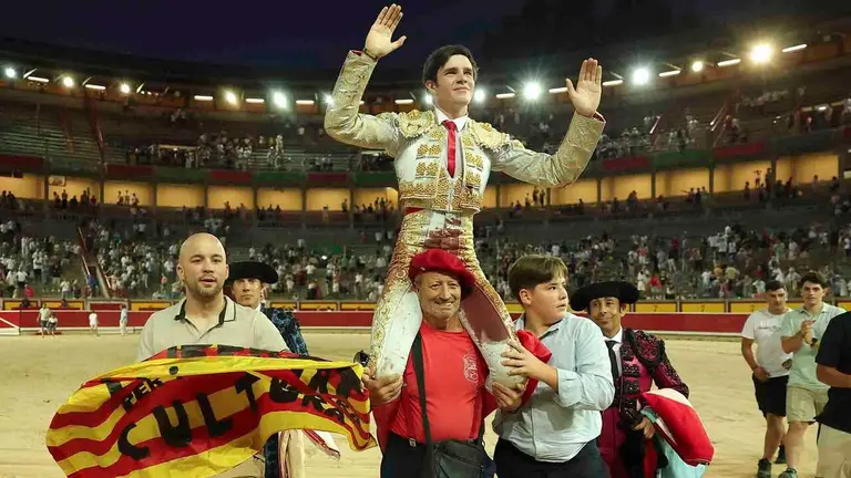 El novillero Mario Vilau sale a hombros de la Monumental de Pamplona tras cortar las dos orejas a su primer novillo de la tarde en la primera de abono de la Feria del Toro de los Sanfermines 2026 con novillos de la ganader&iacute;a navarra De Pincha y en la que ha compartido cartel con los diestros Emiliano Osornio y &Aacute;lvaro Serrano. EFE / J.P. Urd&iacute;roz