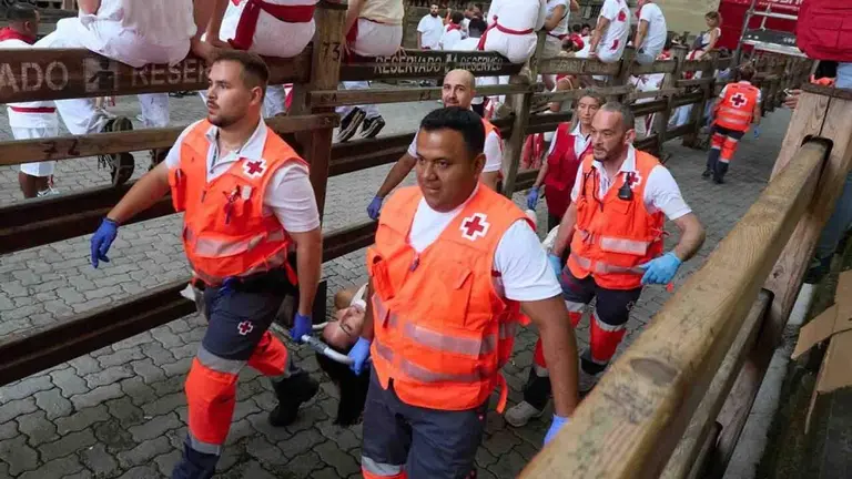 Voluntarios de Cruz Roja atienden a un herido en el quinto encierro de los Sanfermines 2026, con toros de Jos&eacute; Escolar. EDUARDO SANZ - EUROPA PRESS