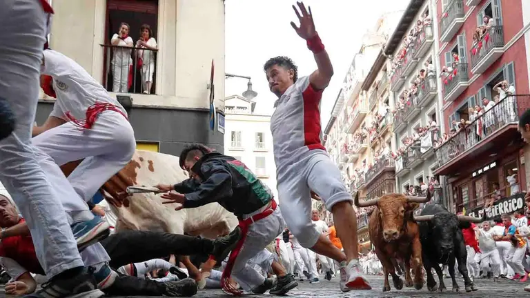 PAMPLONA, 12/07/2026.- Los toros de la ganader&iacute;a gaditana de La Palmosilla entran en la curva de Mercaderes durante el sexto encierro de los Sanfermines 2026, este domingo en Pamplona. EFE/Villar L&oacute;pez
