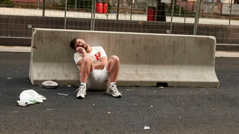 Un joven durmiendo en el Paseo de Sarasate durante las fiestas de San Ferm&iacute;n. IRANZU LARRASOA&Ntilde;A