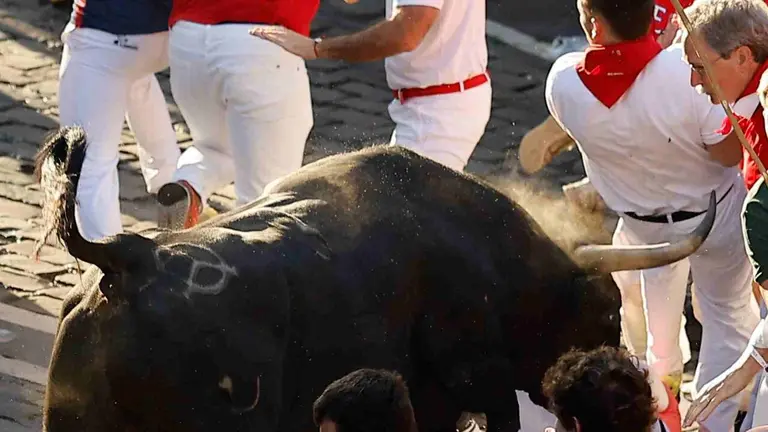 Un toro de la ganader&iacute;a extreme&ntilde;a de Jandilla embiste a varios mozos al principio de la calle Mercaderes, durante el &uacute;ltimo encierro de los Sanfermines 2026, este martes en Pamplona. EFE/Villar L&oacute;pez