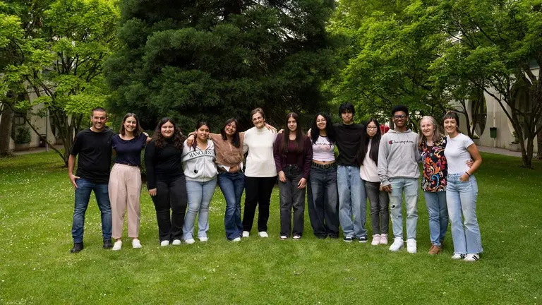 Representantes de la UPNA, del Programa Prometeus y del IES Plaza de la Cruz posan con parte del alumnado y la voluntaria Mar&iacute;a Piedad Hualde (8.&ordf; por la dcha.). UPNA