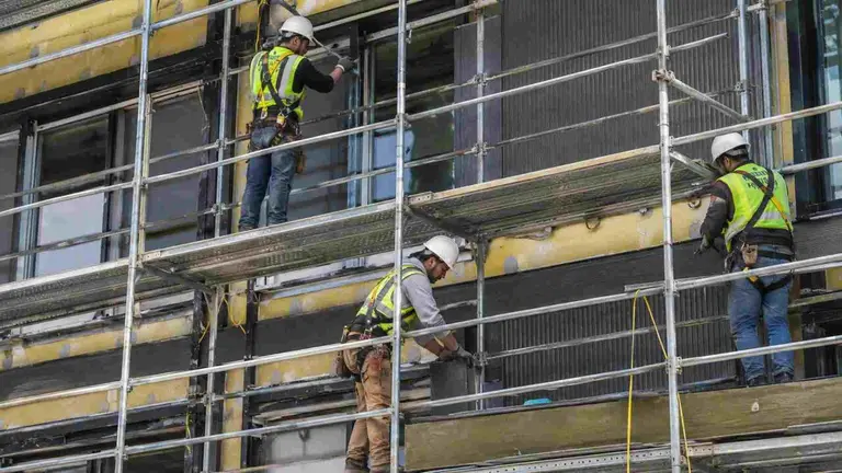 Operarios de la construcci&oacute;n en un andamio.