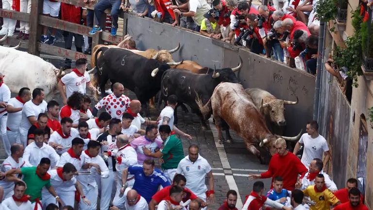Los toros de la ganadería gaditana Núñez del Cuvillo a su llegada a la curva la calle de la Estafeta durante el primer encierro de los Sanfermines 2022. EFE