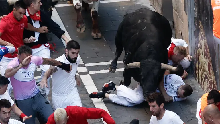 Un toro de la ganadería gaditana de Fuente Ymbro atropieza con varios corredores su paso por la calle de la Estafeta durante el segundo encierro de los Sanfermines 2022, EFEJesús Diges