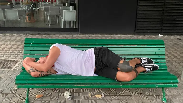 Joven durmiendo en un banco de las calles de Pamplona en San Fermín 2022. PACHI CERVANTES