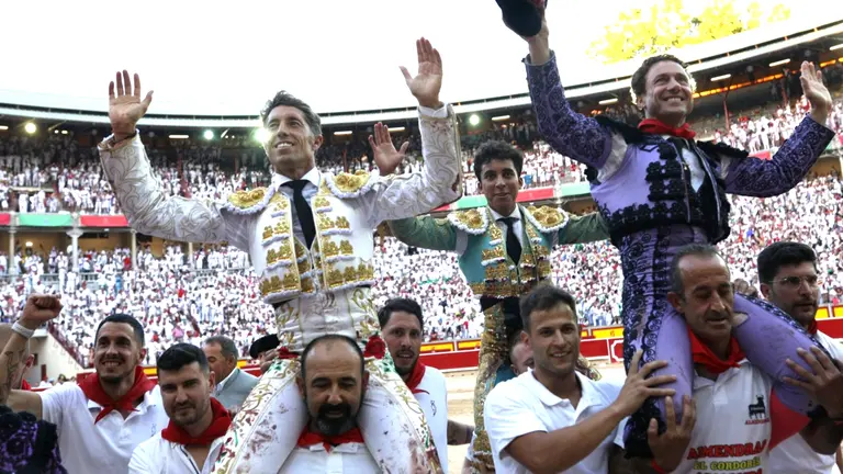 Los diestros Rafaelillo (d), Manuel Escribano (i) y Leo Valadez salen a hombros de la Plaza de Toros de Pamplona tras cortar dos orejas cada uno a su primeros toros de la tarde en la quinta de abono de la Feria del Toro de los Sanfermines 2022 con toros de la ganadería gaditana de La Palmosilla. IÑIGO ALZUGARAY