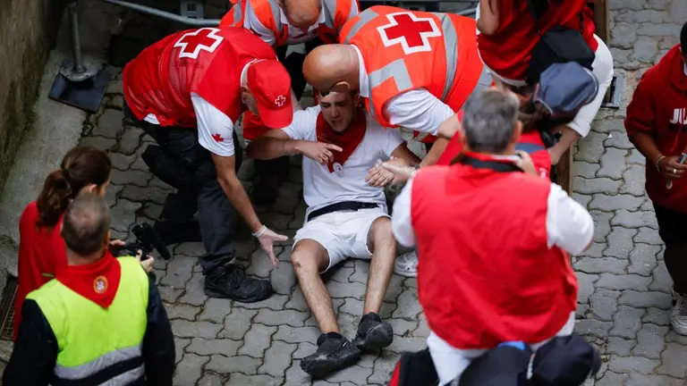 Atenciones sanitarias en el último encierro de San Fermín 2022 con toros de la ganadería de Miura en la bajada al callejón. REUTERS Juan Medina