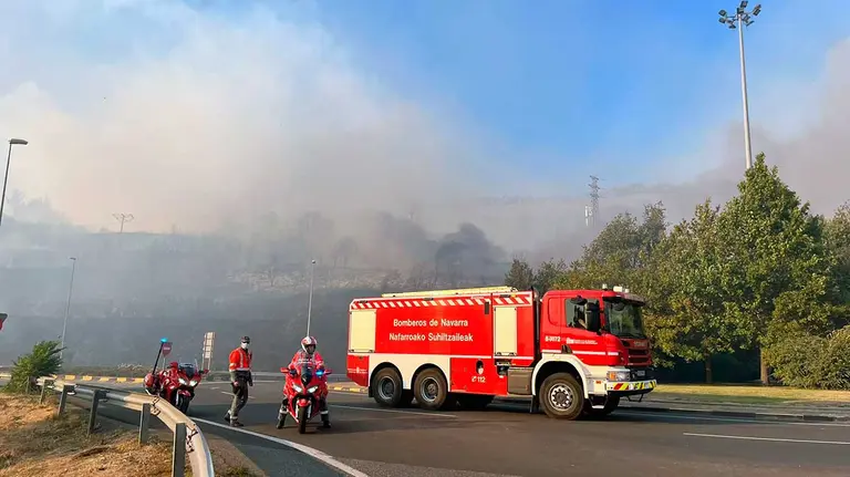 Una dotación de bomberos y una patrulla de la Policía Foral a los pies de San Cristóbal en el incendio de este martes. PABLO LASAOSA