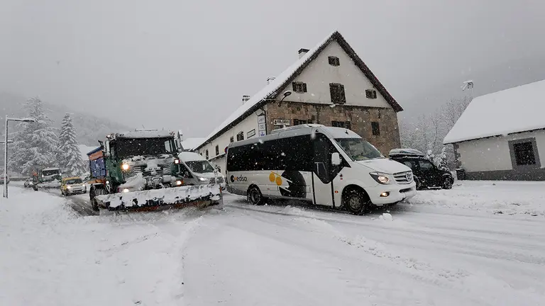 Un microbus escolar deja paso a dos camiones quitanieves en Roncesvalles donde una intensa nevada caída durante la jornada de este lunes cubre completamente la carretera. EFE/ Jesus Diges / ARCHIVO
