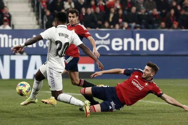 El delantero brasileño del Real Madrid, Vinicius Jr. (i), se lleva el balón ante David García, durante el encuentro correspondiente a la jornada 22 de primera división. EFE / Jesus Diges.