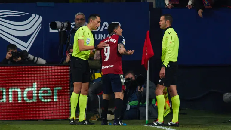 José María Sánchez Martínez (árbitro del partido) y Chimy Avila (9. CA Osasuna) durante el partido de la Liga Santander entre CA Osasuna y RC Celta disputado en el estadio de El Sadar en Pamplona. IÑIGO ALZUGARAY