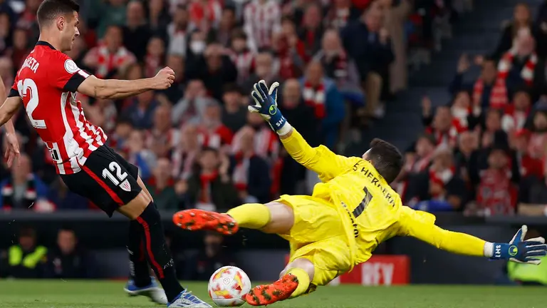 El delantero del Athletic Club de Bilbao Gorka Guruzeta (i) dispara a puerta ante el guardameta del CA Osasuna Sergio Herrera durante el partido de vuelta de semifinales de la Copa del Rey de fútbol que disputan ambos equipos este martes en el Estadio San Mamés de Bilbao. EFE/ Miguel Toña