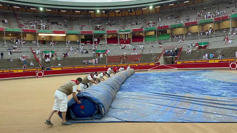 Operarios retiran la lona del ruedo de la plaza de toros de Pamplona minutos antes de la primera corrida de San Fermín. NAVARRA.COM