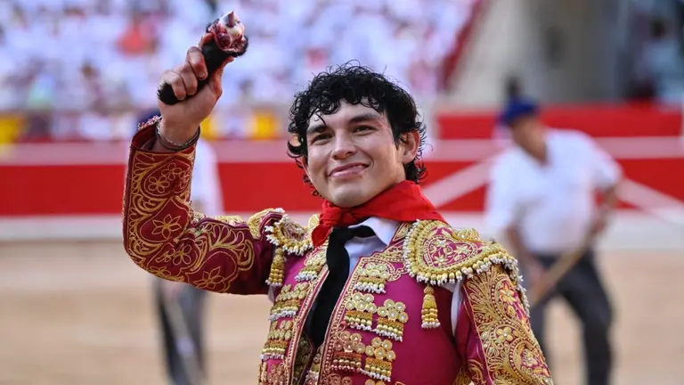 El diestro Isaac Fonseca con la oreja concedida en la lidia de su primer toro en suerte esta tarde en la Plaza de Toros de Pamplona dentro de la Feria del Toro de los Sanfermines 2023, donde ha compartido cartel con Adrián Torres y Román Collado con toros de la ganadería gaditana de José Cebada Gago.  PABLO LASAOSA