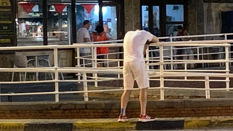 Un joven apoyado en una barandilla después de una larga noche en San Fermín 2023. PATXI CERVANTES
