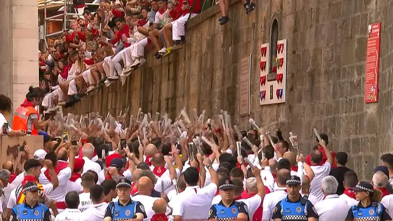 Corredores ante la hornacina de San Fermín en la cuesta de Santo Domingo antes del sexto encierro de San Fermín 2023 con toros de la gandería de Jandilla.
